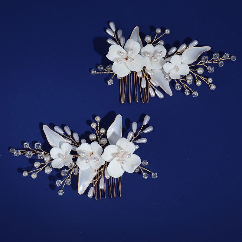 Two white floral hair comb designs displayed against a dark blue background