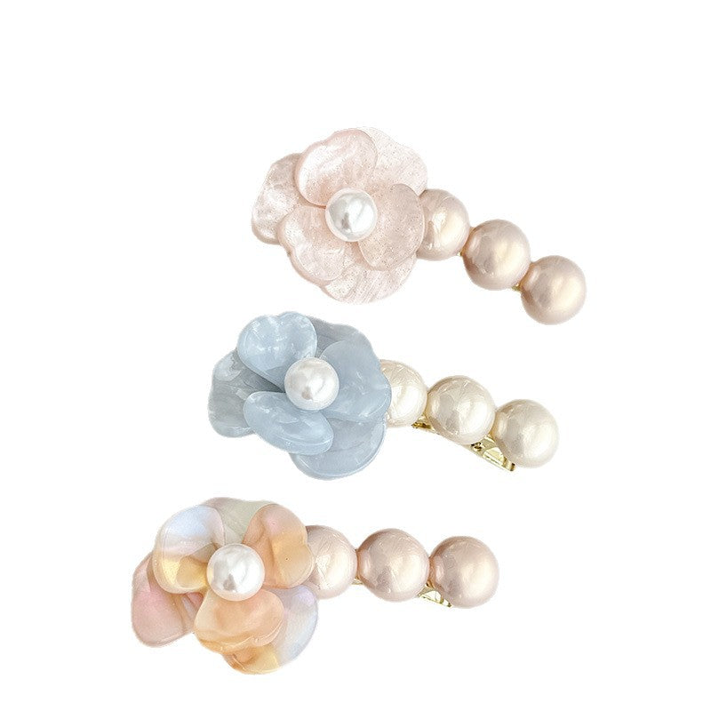 Acetate side hair clip with a flower-shaped detail and pearl accents in six colors