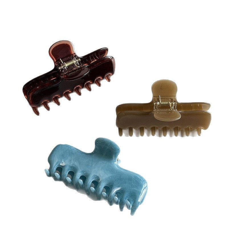 Cellulose acetate claw clip in deep brown, light brown, and light blue
