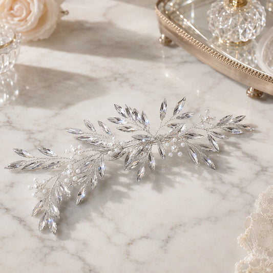 Silver botanical bridal hair accessory displayed on a surface
