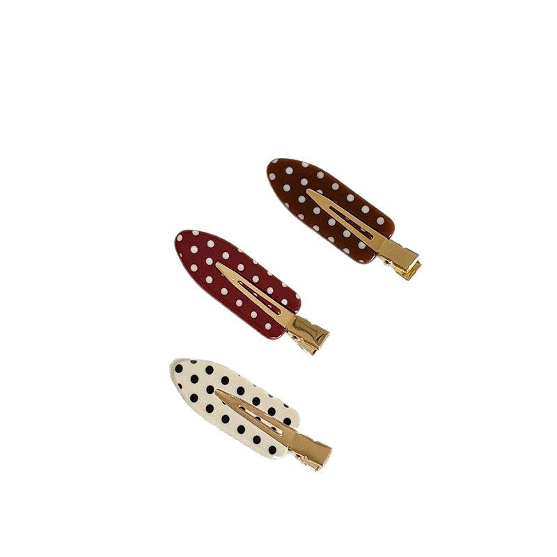 Red, brown, and cream polka dot acetate snap hair clips with gold-tone fastenings