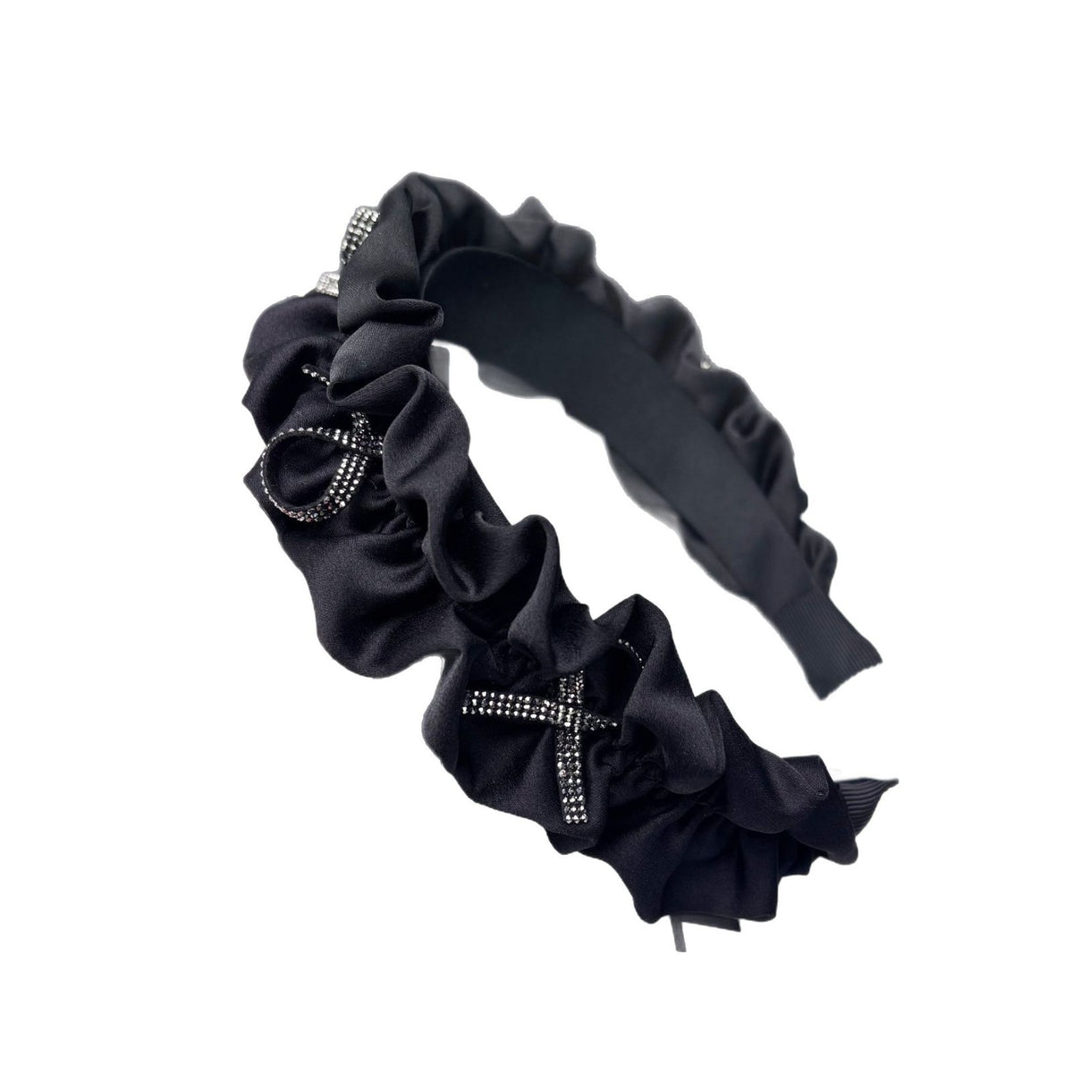 Padded satin headband with ruffled trim and a rhinestone bow, shown against a white background