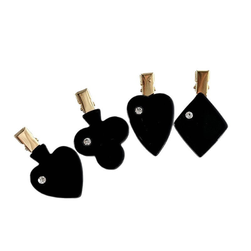 Black acetate side hair clip options shaped like playing card suits with gold-tone fittings and rhinestone accents.