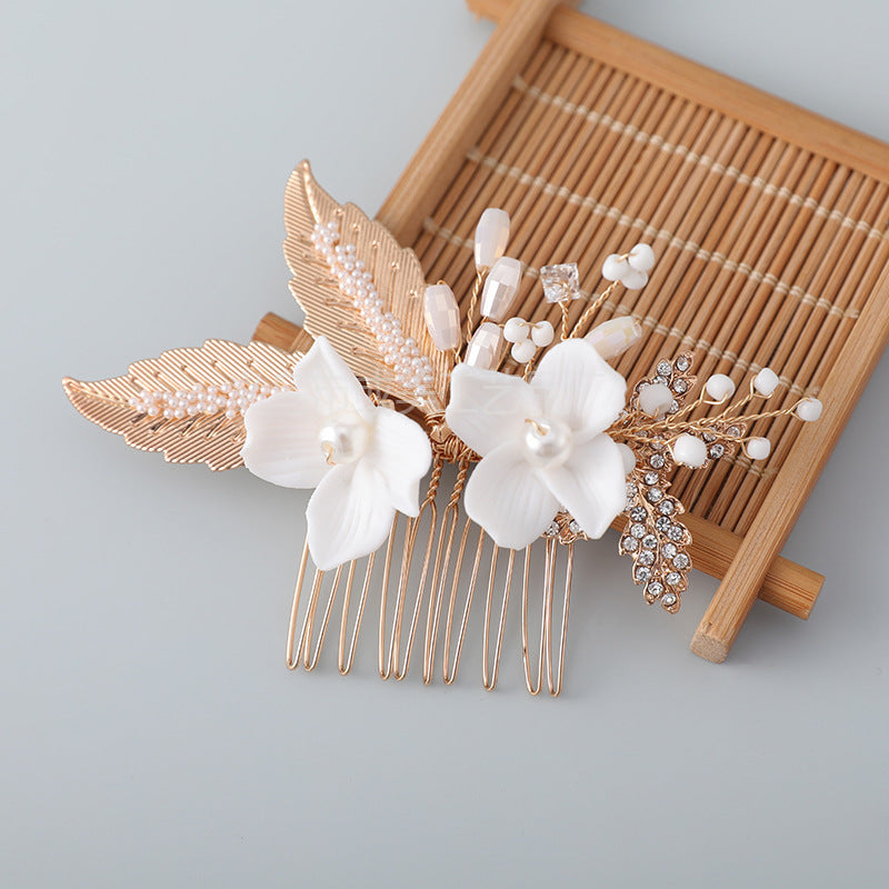 Gold tone ceramic flower hair comb with faux pearls and crystals on a bamboo mat