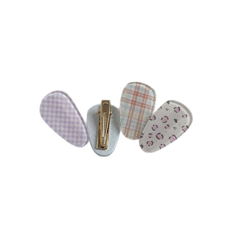 Acrylic patterned side hair clips with glitter detail and a gold-tone metal back