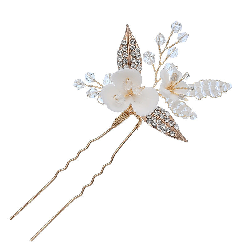 Gold hair pin with a white flower and sparkling crystal embellishments
