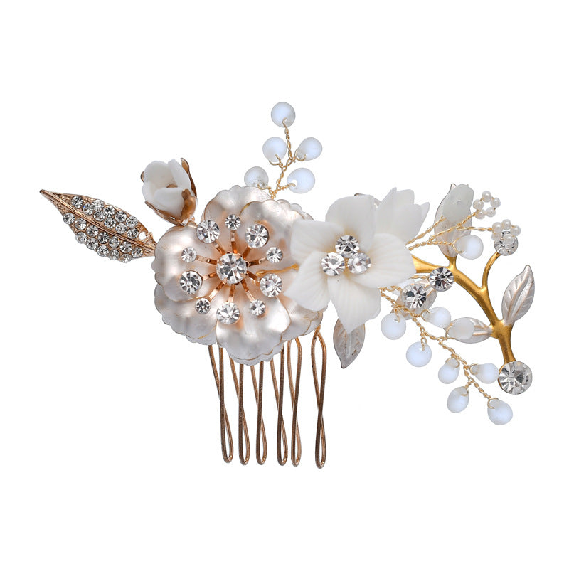 White ceramic flower hair comb with clear rhinestones on a gold-color branch design