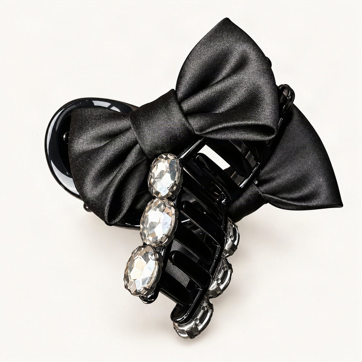 Hand holding black rhinestone bow claw clip to show its details [FITINY Hair]