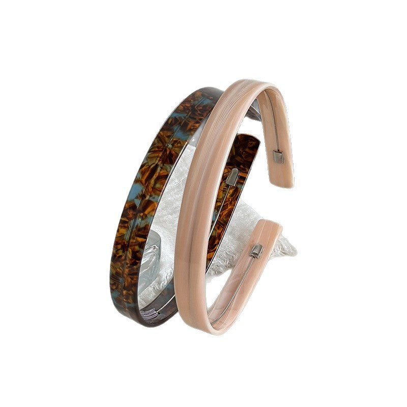 Wide cellulose acetate headbands in patterned brown and blush pink finishes