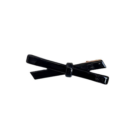 Black cellulose acetate bow side hair clip on a clean white background
