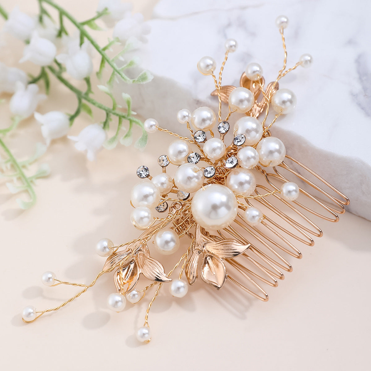 Close-up of the decorative comb's faux pearls, clear accents, and alloy leaves