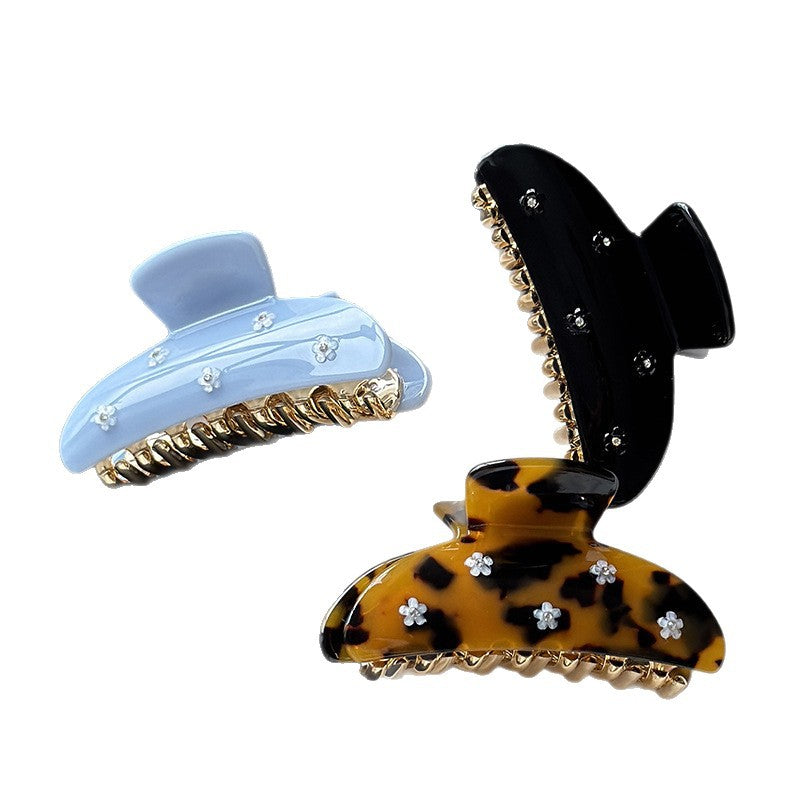 Tortoise, light blue, and black acetate claw clips with floral rhinestone details
