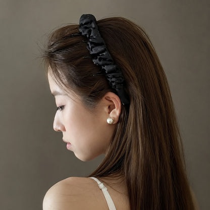 Ruched satin headband with rhinestone details worn in long hair