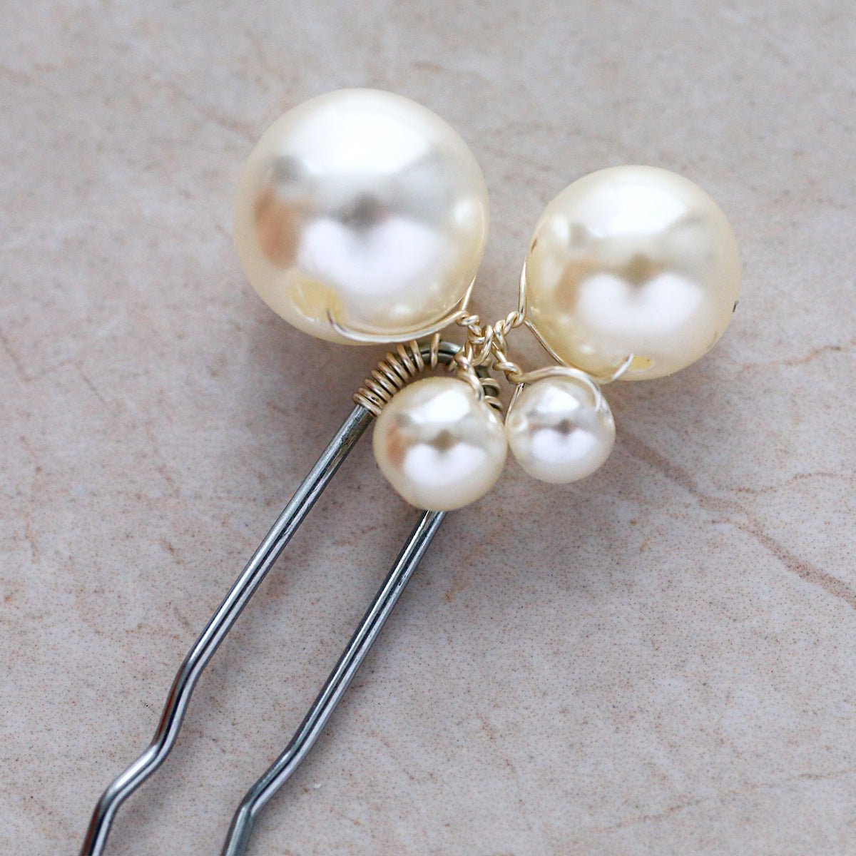 Detail view of faux pearl embellishments on silver-colored hair pins