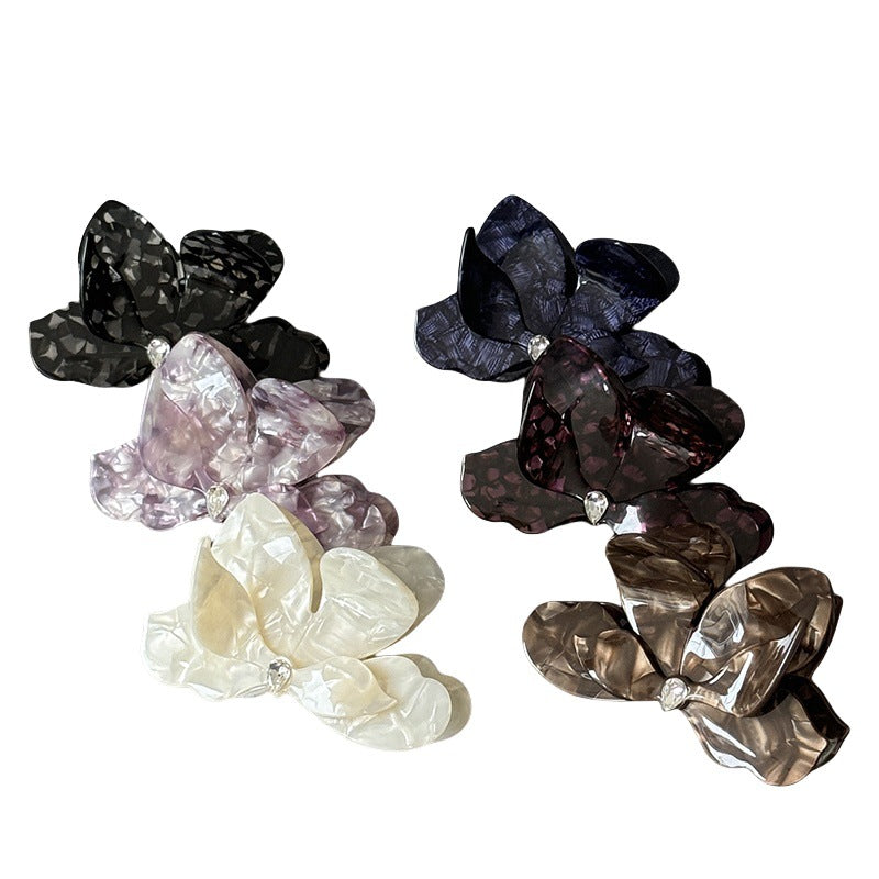 Lifestyle close-up of acetate claw clip with 3D bougainvillea and rhinestones in styled hair