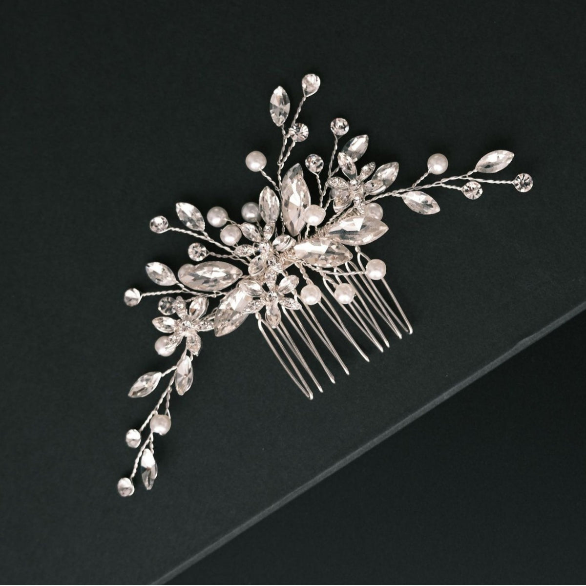 Close view of silver bridal hair comb with crystal and pearl embellishments