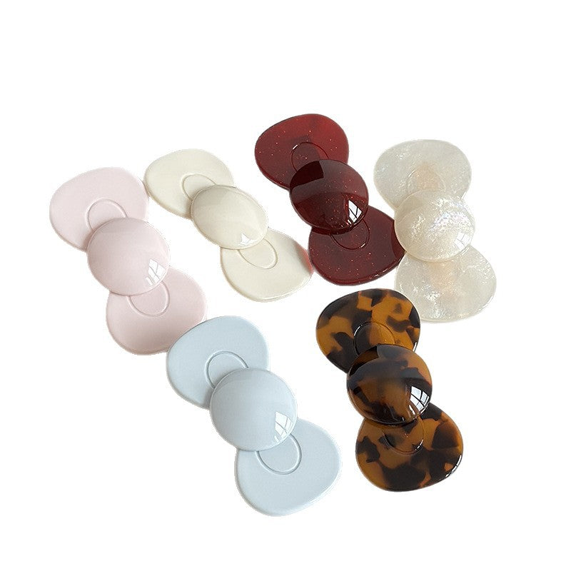 Six glossy cellulose acetate bow hair clips in cream, tortoise, pink, mermaid, burgundy, and light blue