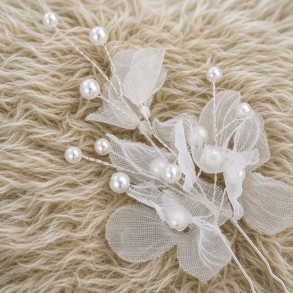 Close-up of sheer organza petals and faux pearl details on a hair pin