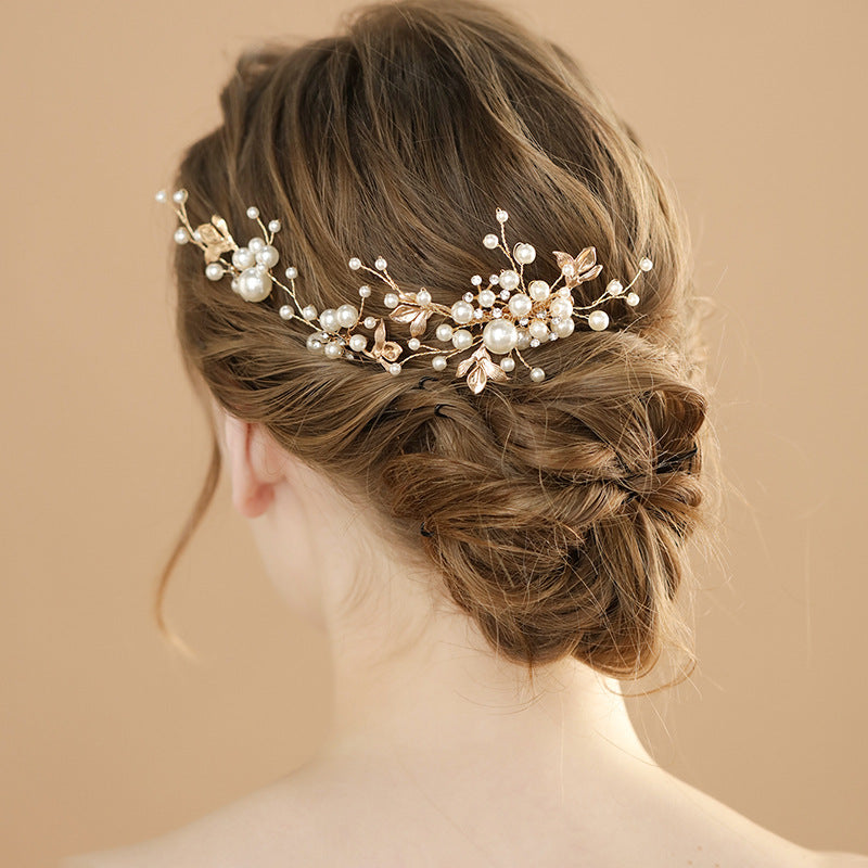 Back view of a low bun adorned with a branching faux pearl hair accessory