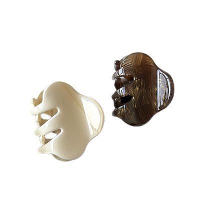 Cream and brown small cellulose acetate claw clips shown from the side