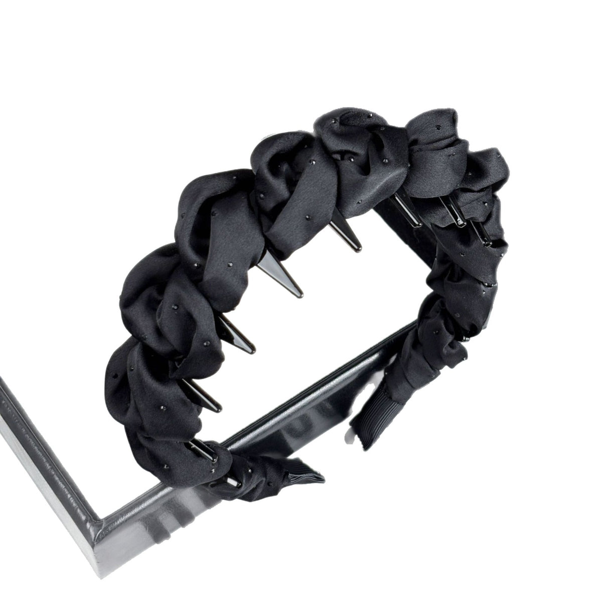 Curved headband showing its ruched fabric and inner band