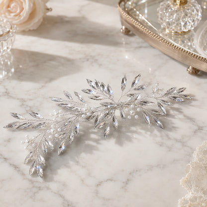 Silver botanical bridal hair accessory displayed on a surface