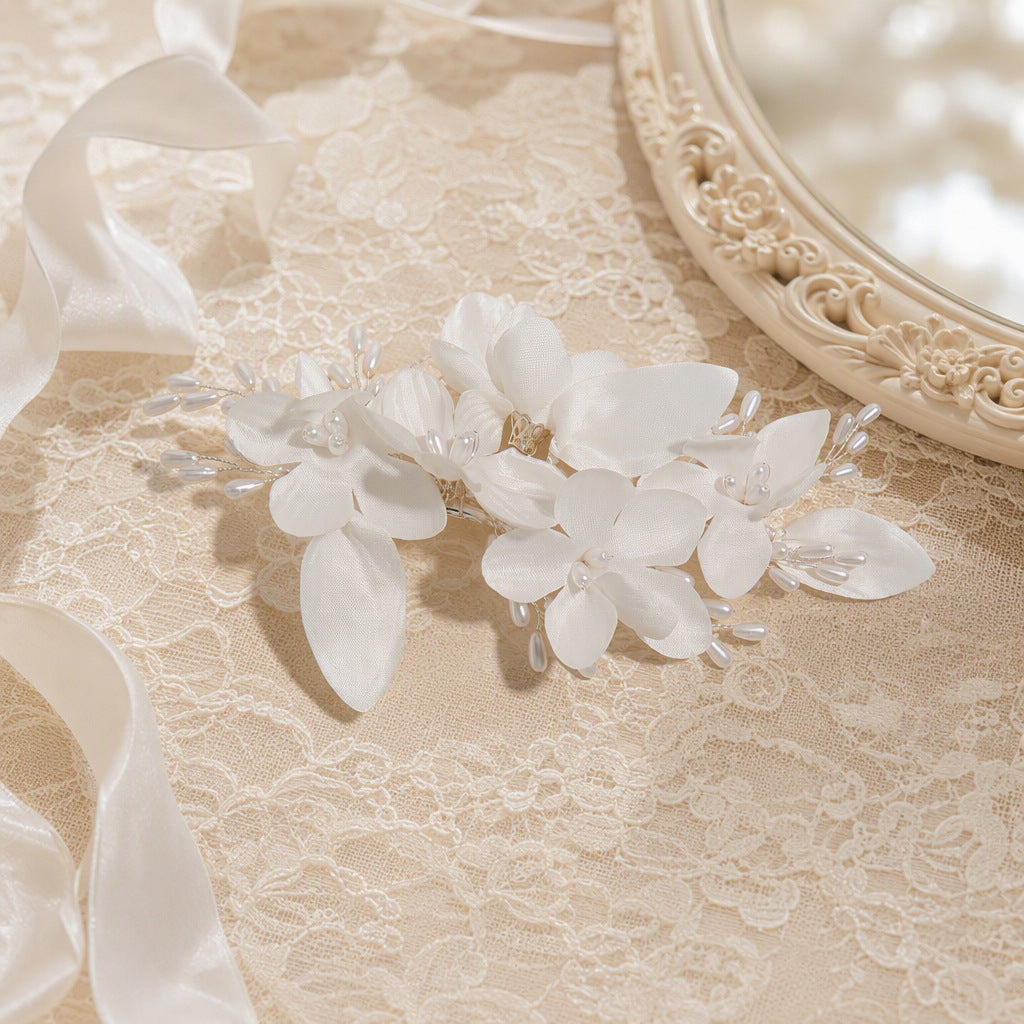 Close-up of layered fabric flowers and faux pearl accents on a hair clip
