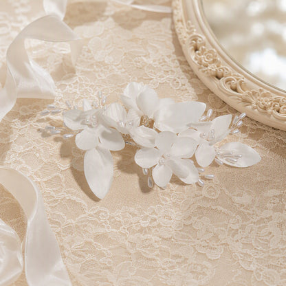 Close-up of layered fabric flowers and faux pearl accents on a hair clip