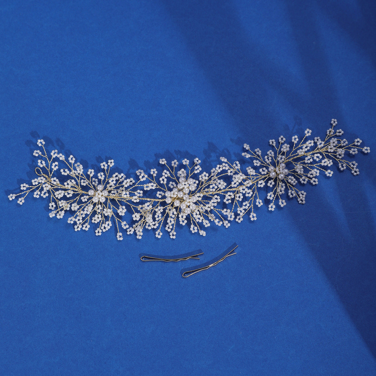 Gold and silver hairpins shown beside the pearl hair vine