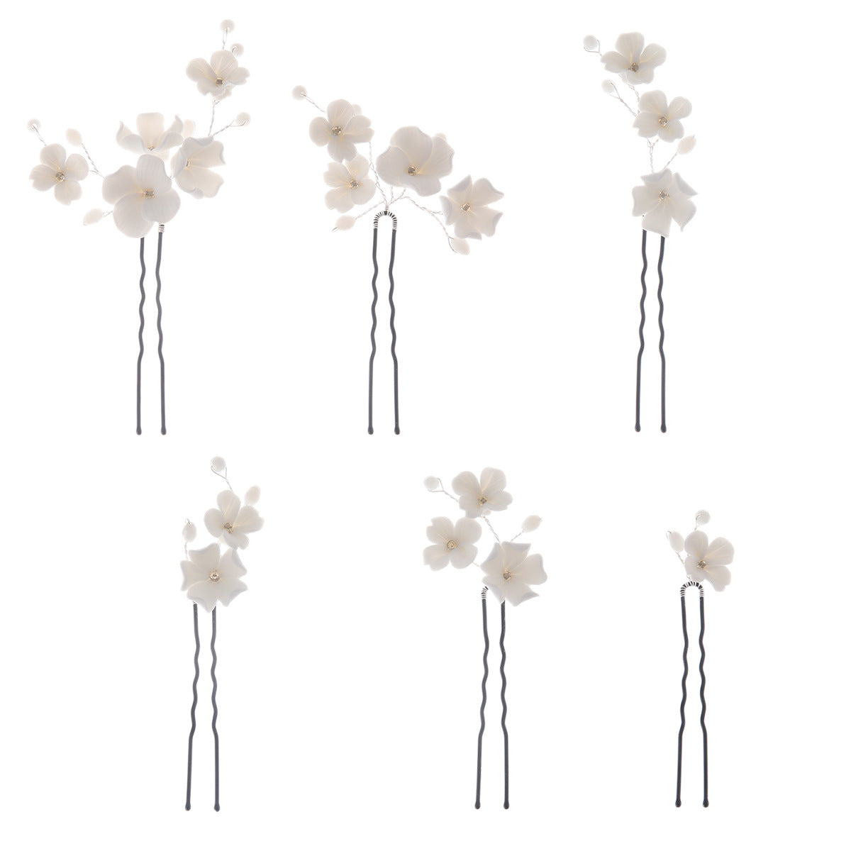 Black wavy U pins with white floral decorations on a plain background