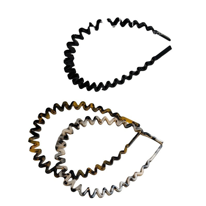 Black wavy cellulose acetate headband with a rippled silhouette
