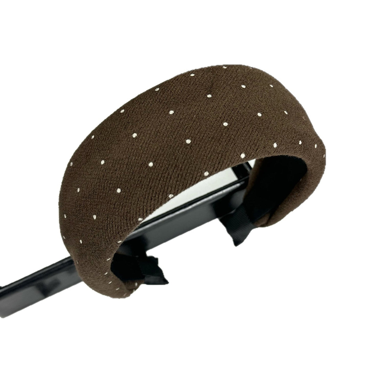 Close-up of the padded fabric headband showing its polka dot pattern and inner edge