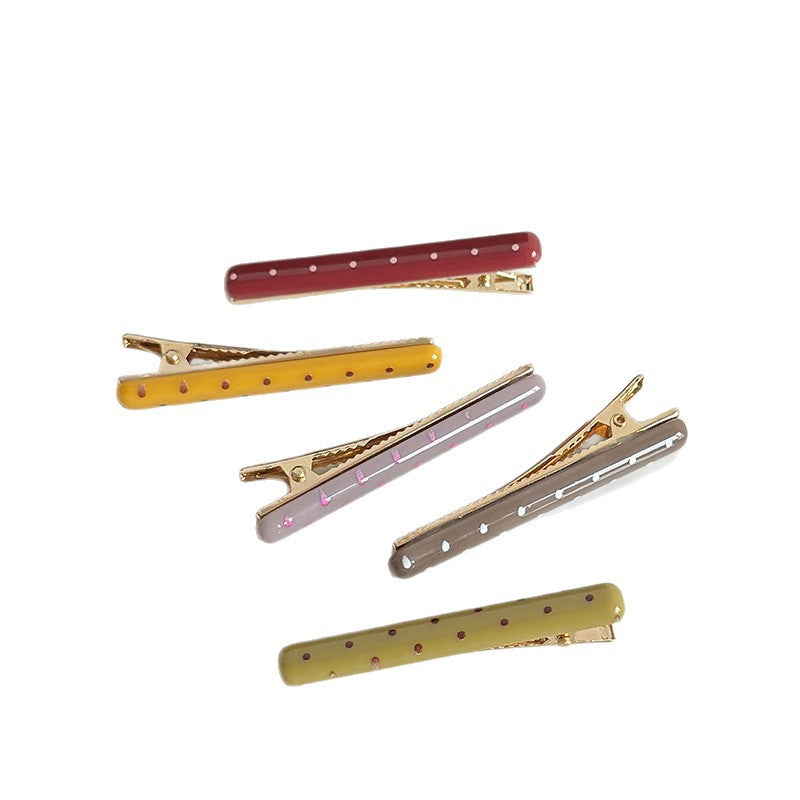 Six slim polka dot acetate side hair clips in assorted colors