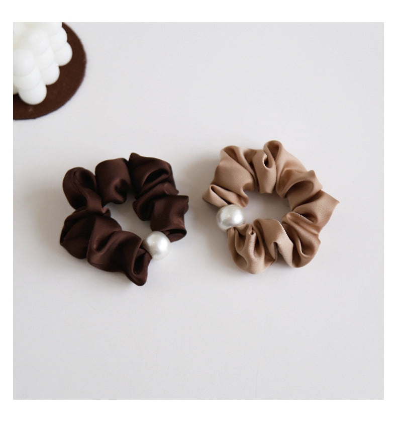 Black satin pearl scrunchie on white background