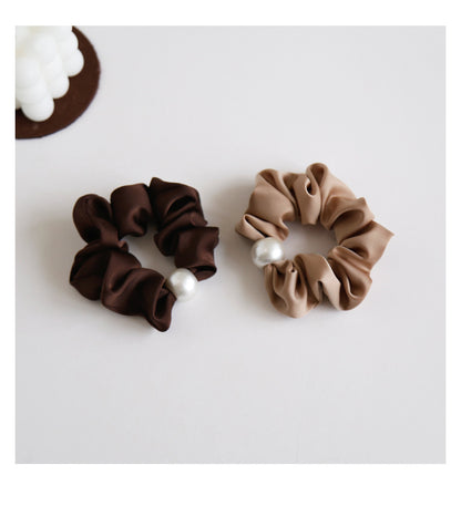 Black satin pearl scrunchie on white background