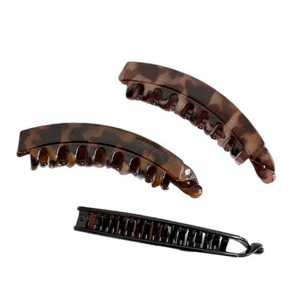 Three curved resin banana hair clips in leopard patterns and dark finishes