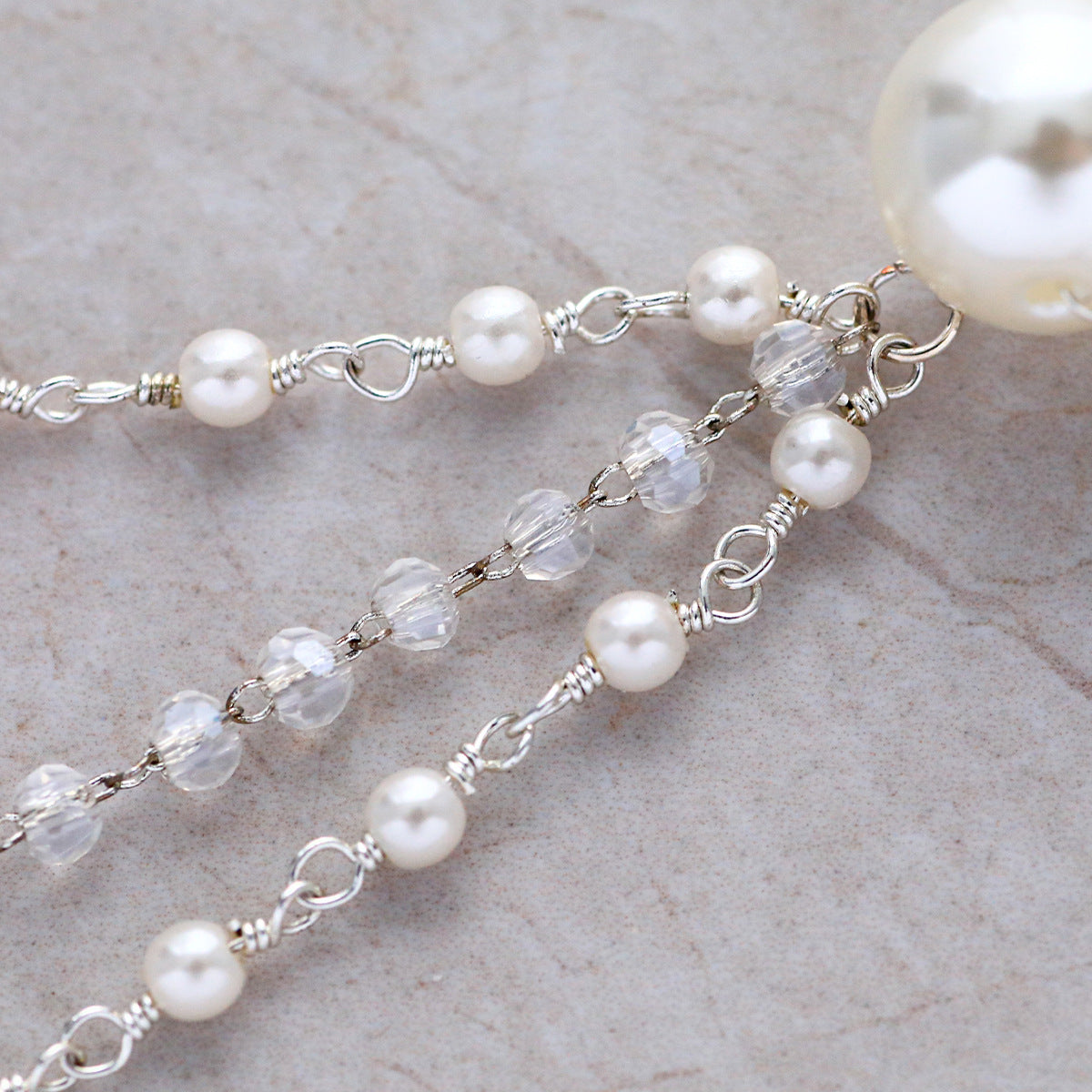 Close-up of faux pearls and clear faceted beads on the hair chain