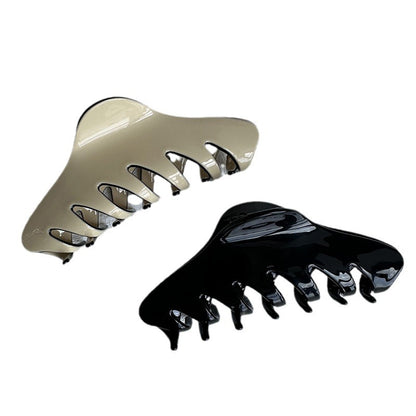 Large black and cream cellulose acetate claw clips shown against a white background