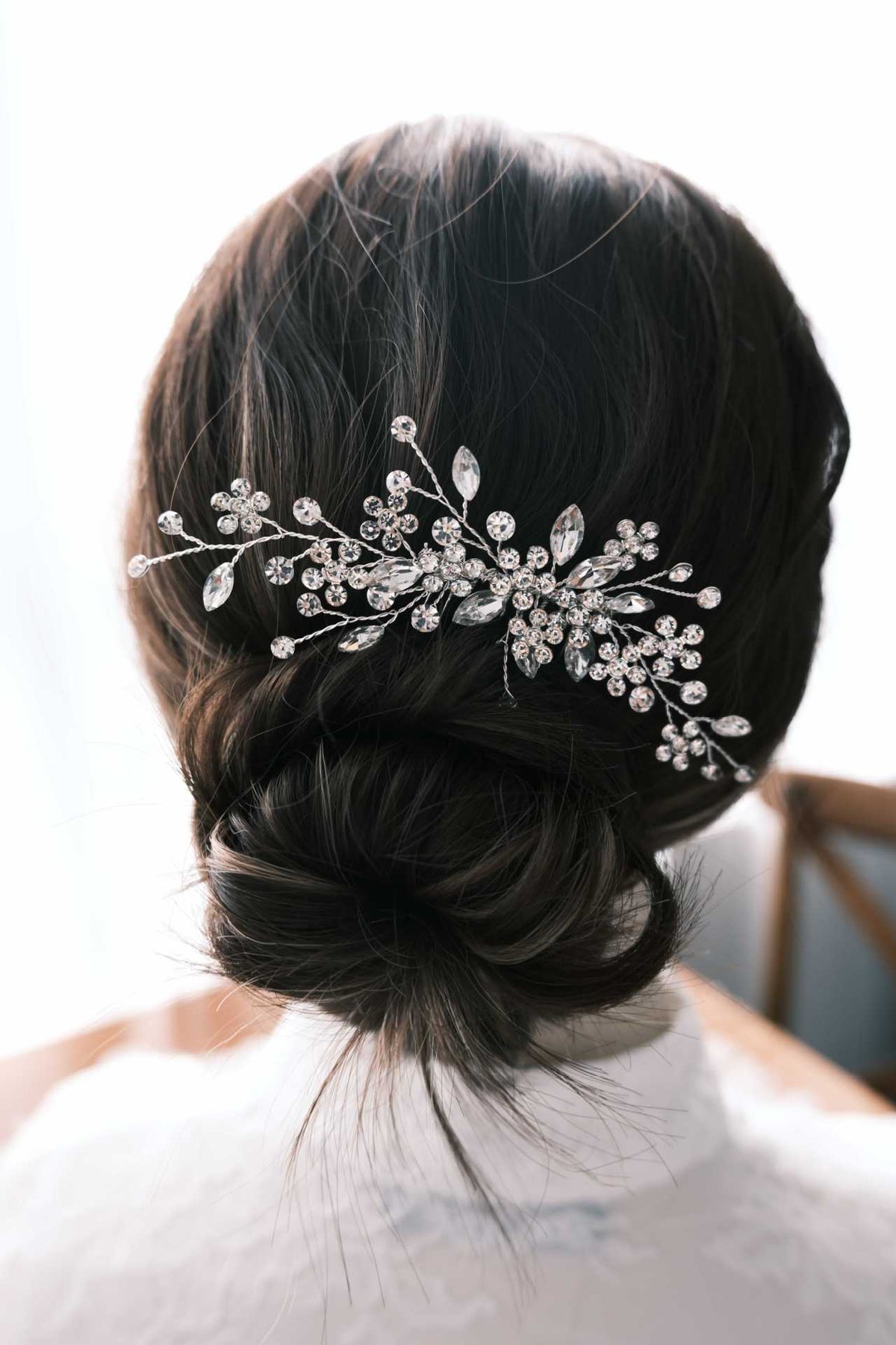 Detailed bridal updo featuring a branching crystal comb