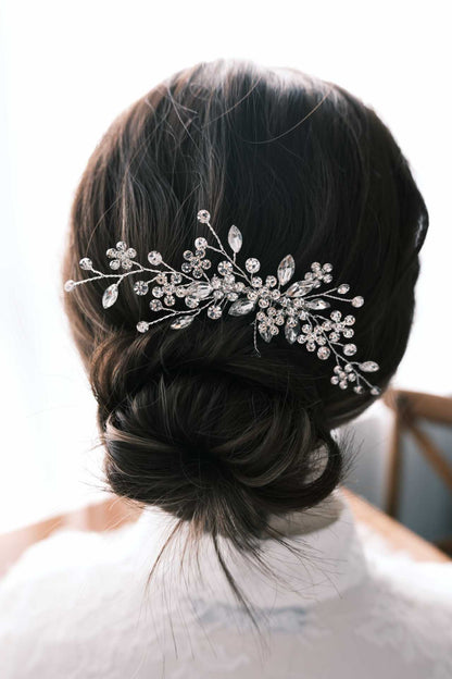 Detailed bridal updo featuring a branching crystal comb