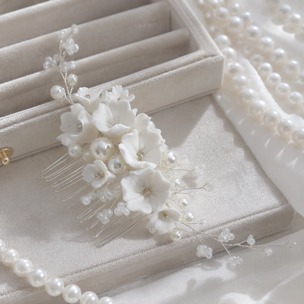 Decorative flower and pearl comb arranged beside a jewelry box