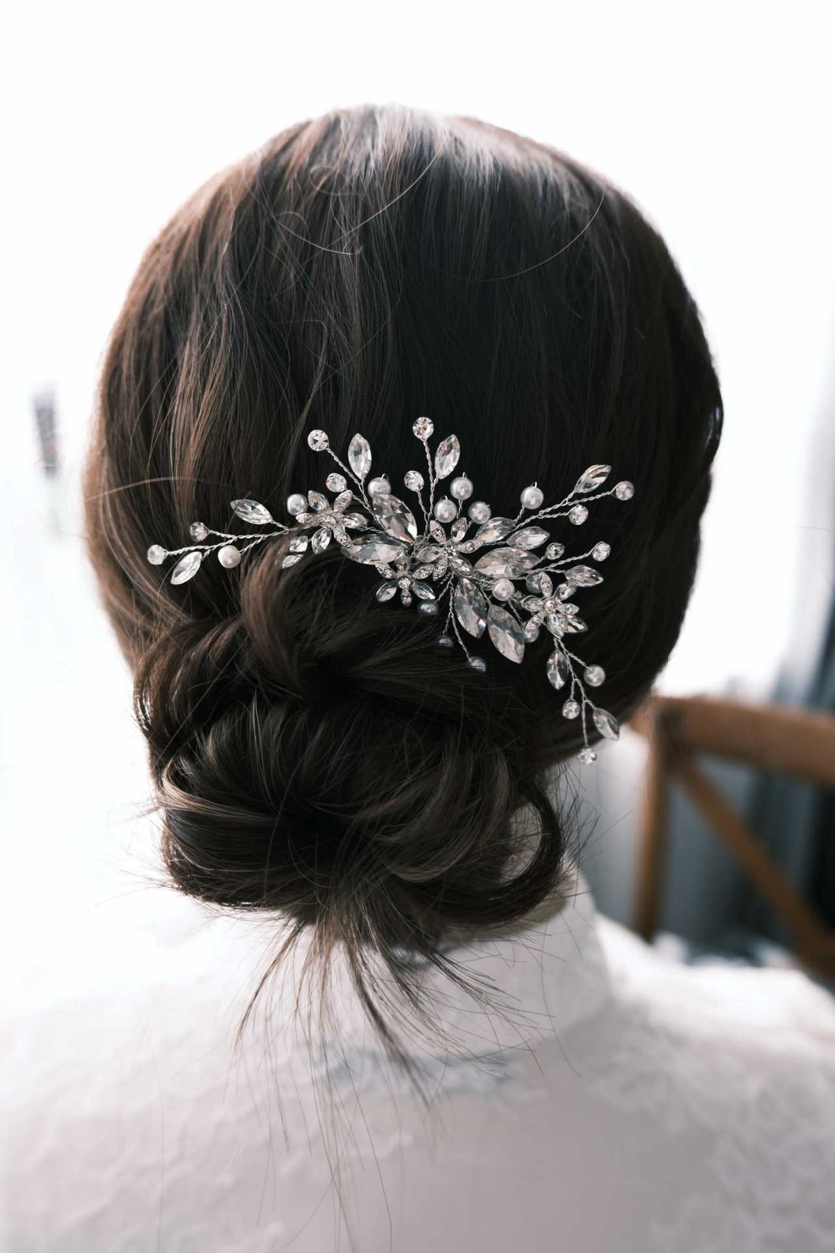 Bridal updo styled with a sparkling crystal and pearl hair comb