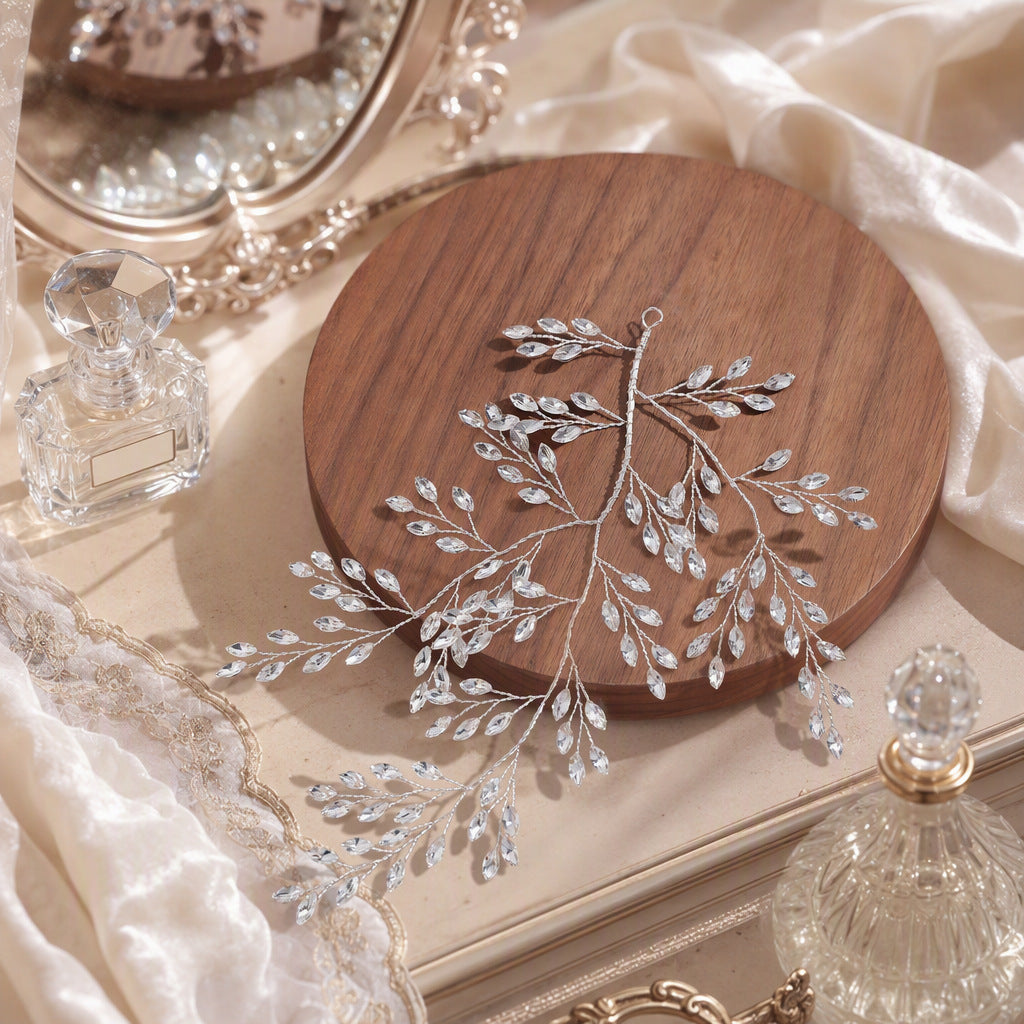 Hand-wrapped rhinestone hair vine arranged on a wooden display