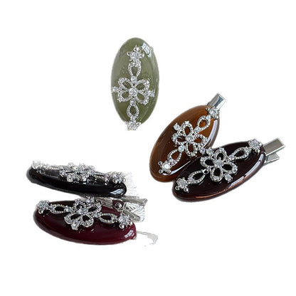 Small acetate duckbill hair clip in assorted jewel-toned colors with floral rhinestone decoration