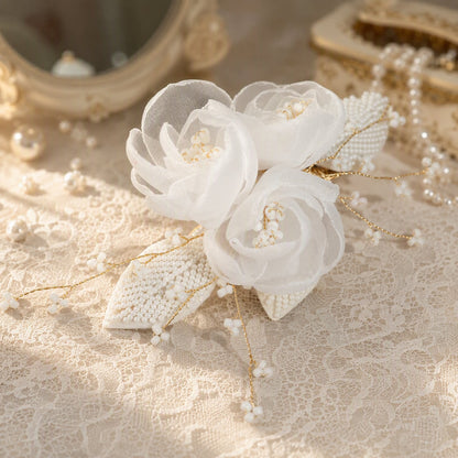 Close view of layered white mesh flowers and faux pearl detailing