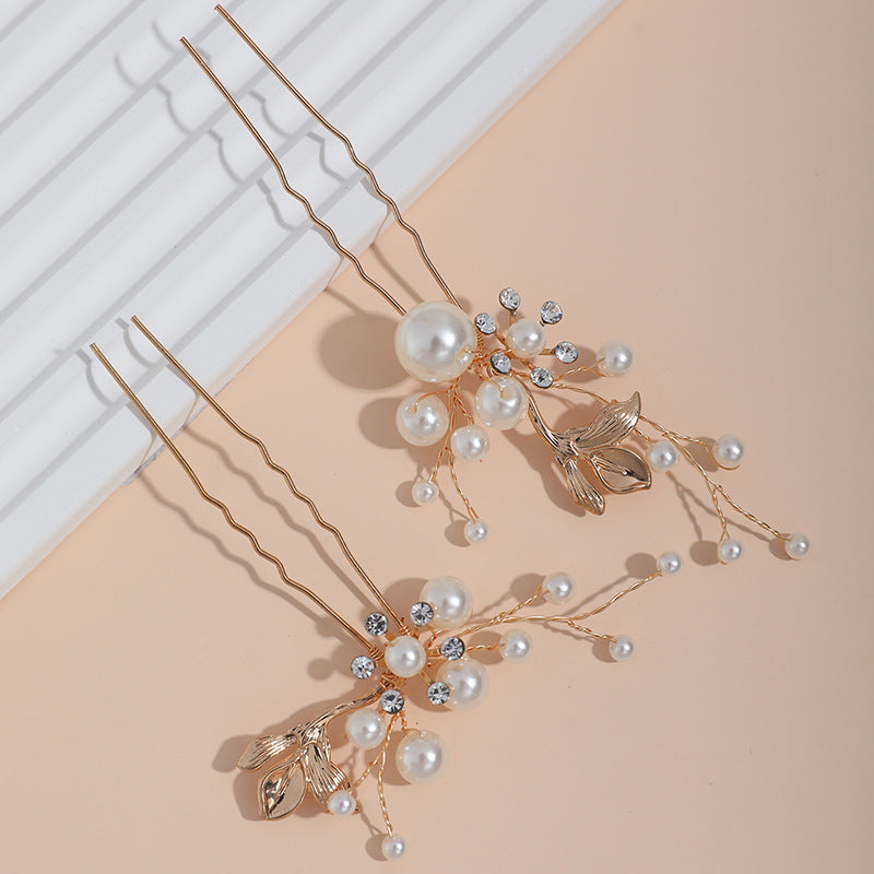 Close-up view of the decorative hair pins and their branching pearl details
