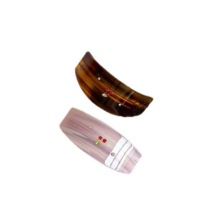 Pink and amber striped acetate spring hair clips with decorative colored accents