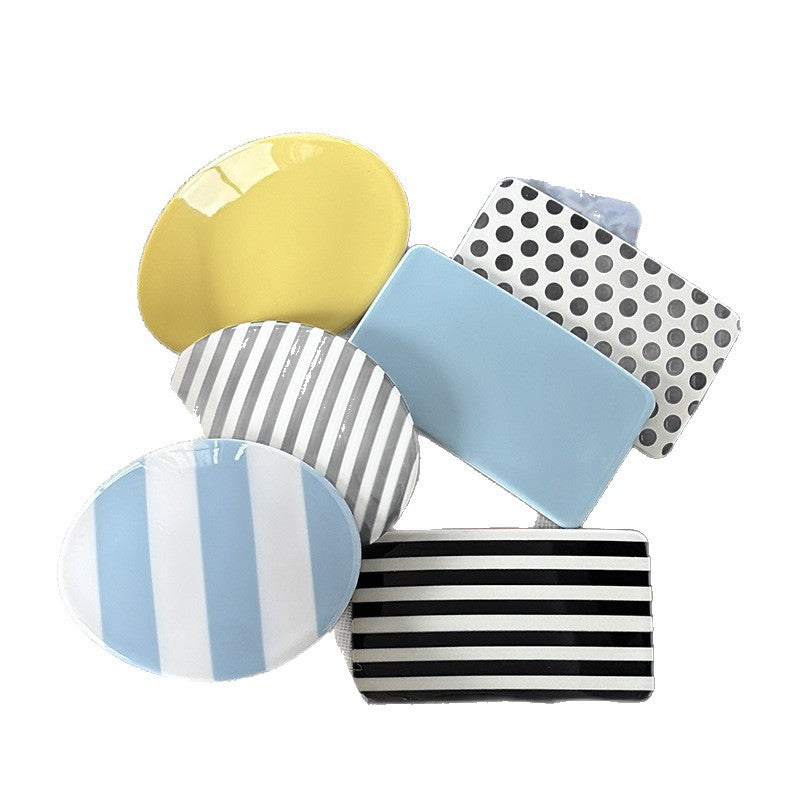 Assorted cellulose acetate spring hair clips in solid colors, polka dots, leopard print, and stripes