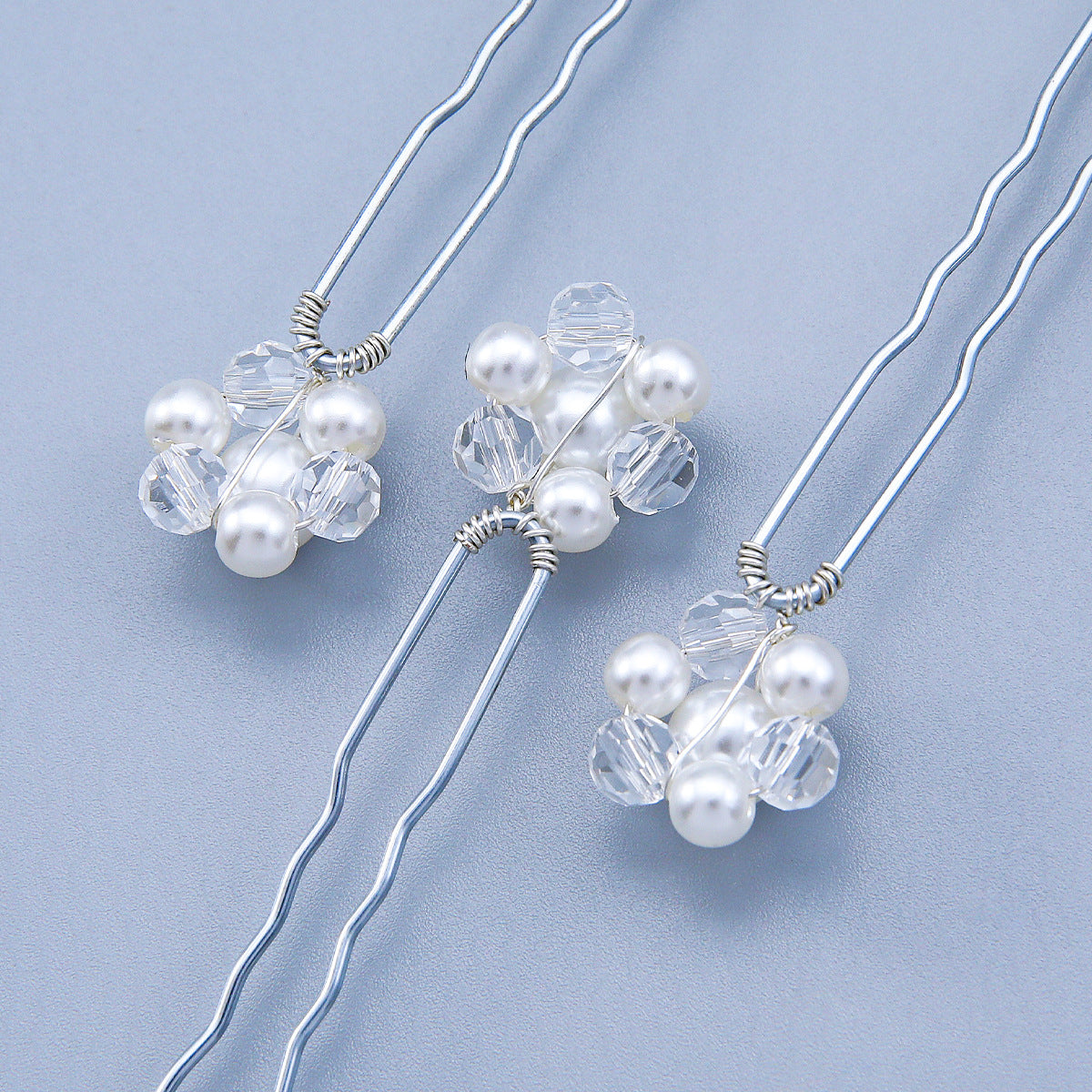 Close-up of faux pearl and clear crystal flower details on U-pins