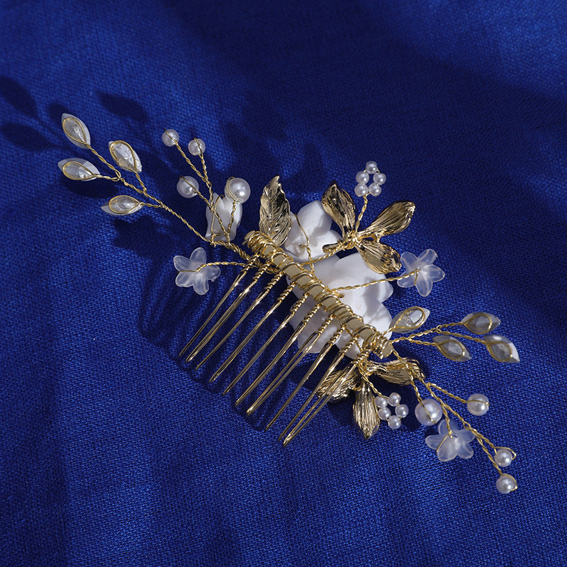 Reverse view of gold-color comb with flower and pearl details